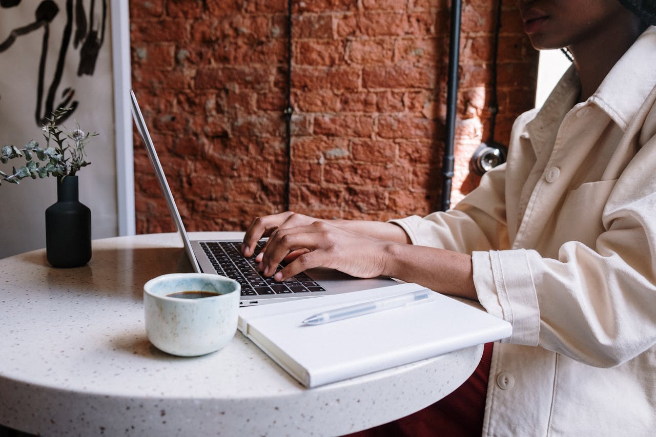why-choose-us-01 Woman working on a laptop with coffee in a cozy café, highlighting a productive and modern vibe.
